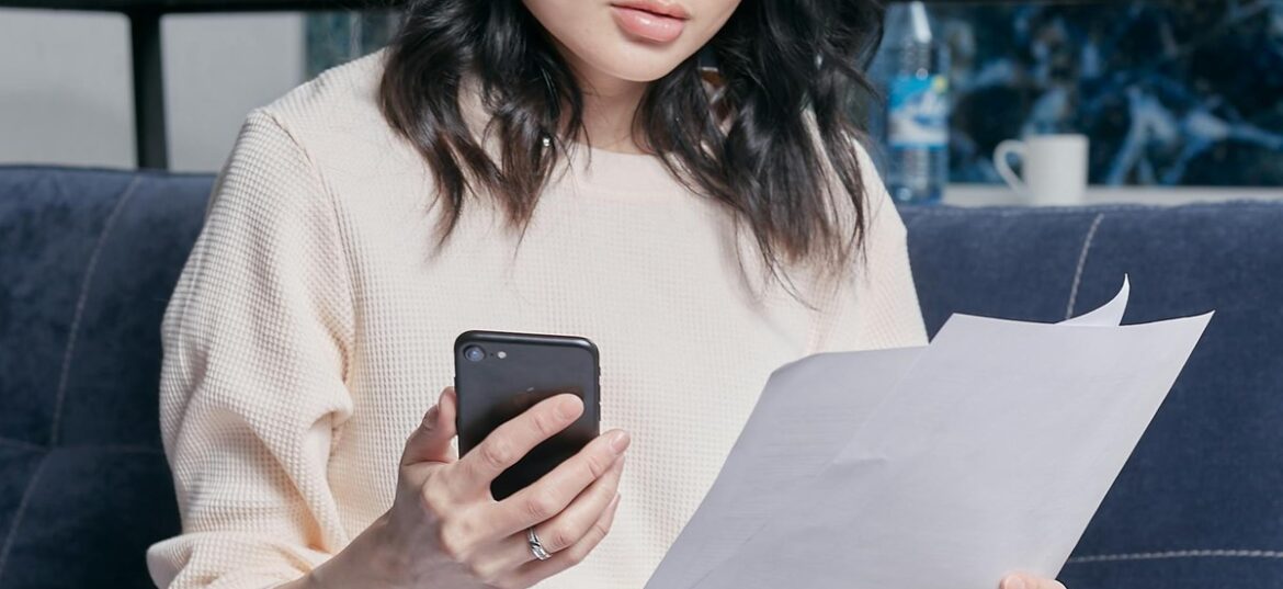 A young woman at home reviewing her tax documents and statements before the 30 June EOFY deadline