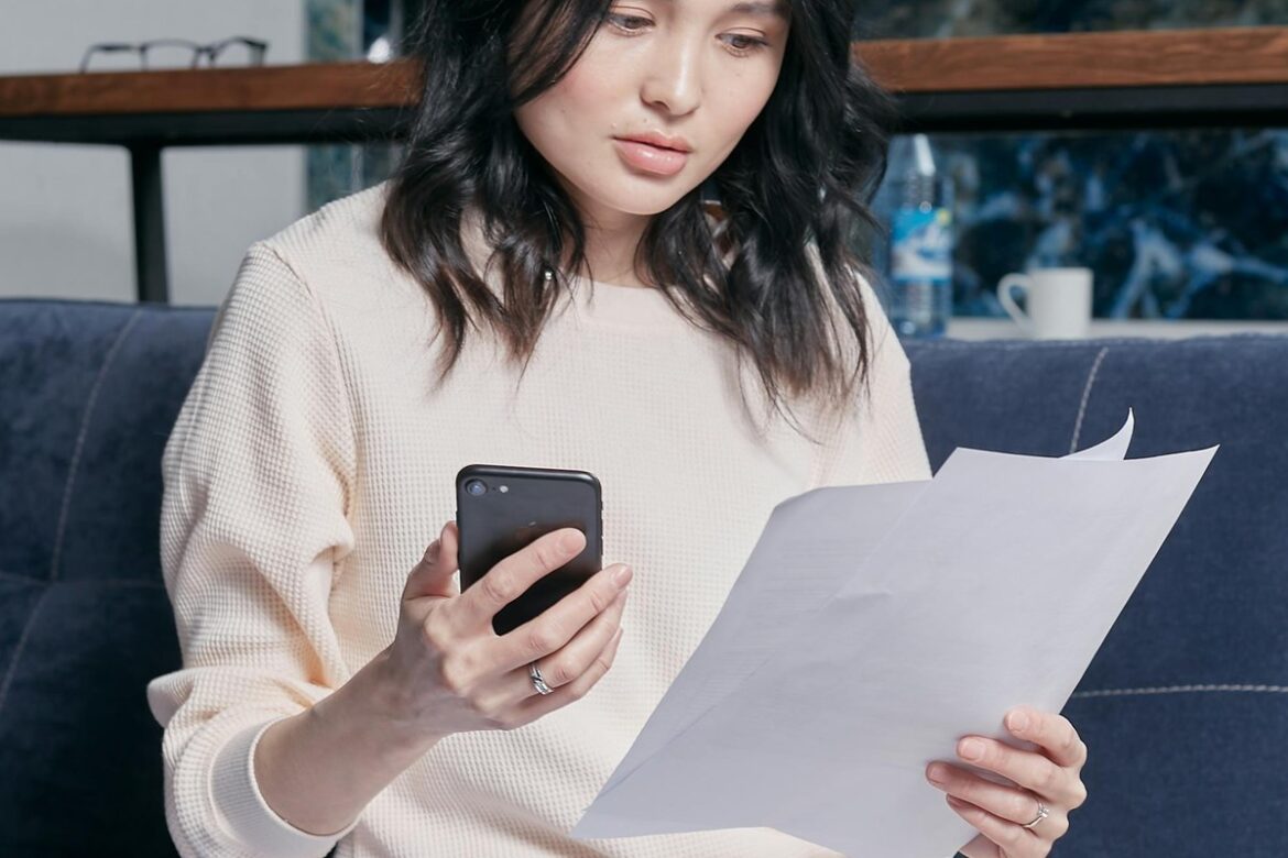 A young woman at home reviewing her tax documents and statements before the 30 June EOFY deadline