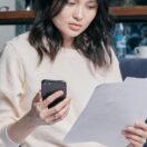 A young woman at home reviewing her tax documents and statements before the 30 June EOFY deadline