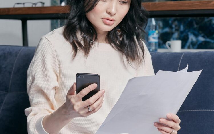 A young woman at home reviewing her tax documents and statements before the 30 June EOFY deadline