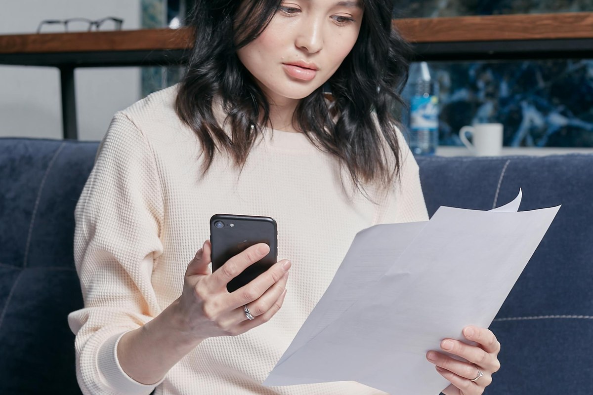 A young woman at home reviewing her tax documents and statements before the 30 June EOFY deadline