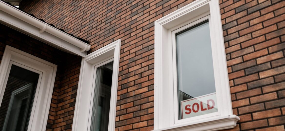 A SOLD sign in the window of a brick house — since 1 January 2025, every Australian property seller needs an ATO clearance certificate or 15% of the sale price is withheld