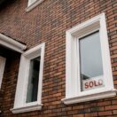 A SOLD sign in the window of a brick house — since 1 January 2025, every Australian property seller needs an ATO clearance certificate or 15% of the sale price is withheld