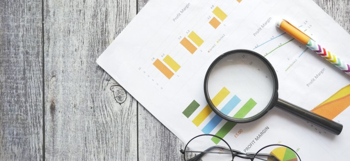 A magnifying glass over financial charts symbolising ATO scrutiny of 2026 tax returns through data matching