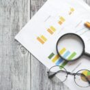 A magnifying glass over financial charts symbolising ATO scrutiny of 2026 tax returns through data matching