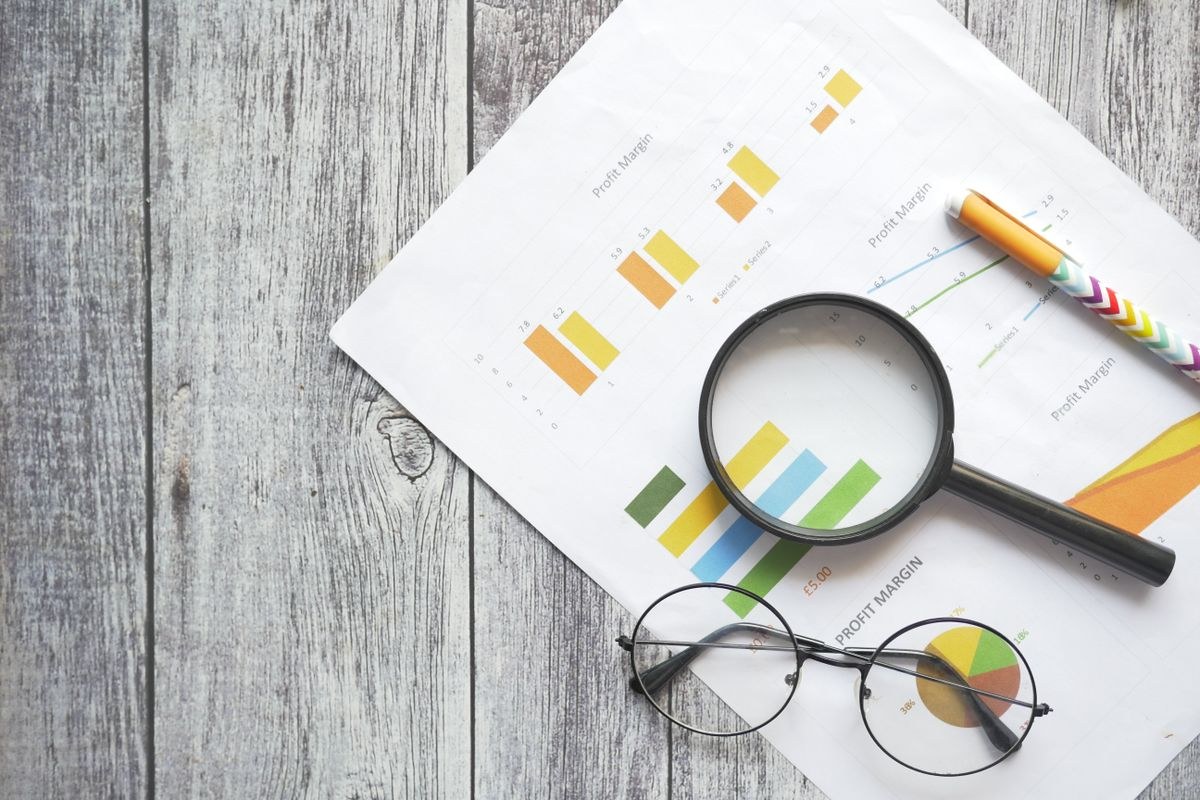 A magnifying glass over financial charts — symbolising the ATO scrutiny of 2026 tax returns through data matching