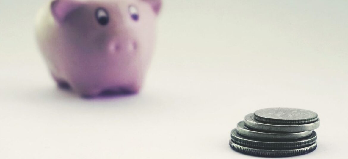 A piggy bank and a small stack of coins, representing an Australian tax refund people are waiting on