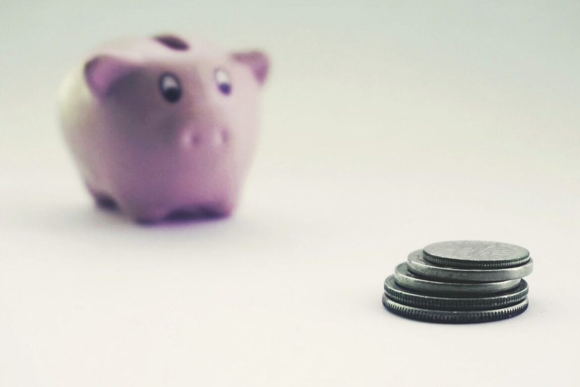 A piggy bank and a small stack of coins, representing an Australian tax refund people are waiting on