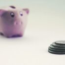 A piggy bank and a small stack of coins, representing an Australian tax refund people are waiting on