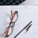 Open year planner and calendar beside a laptop with a deadline sticky note, representing deciding when to lodge a 2026 Australian tax return