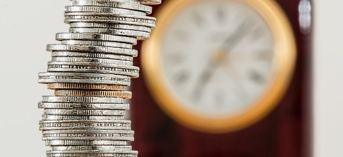 Stacked coins in front of a clock representing the seven business day Payday Super deadline for Australian employers