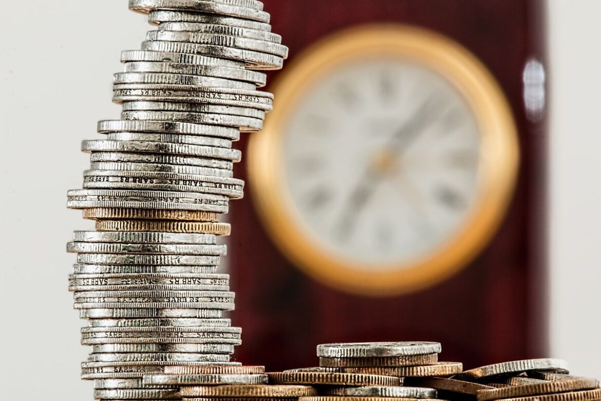 Stacked coins in front of a clock representing the seven business day Payday Super deadline for Australian employers