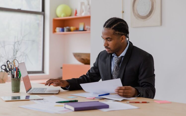 Australian small business owner reviewing documents at a desk while choosing between a sole trader and company structure