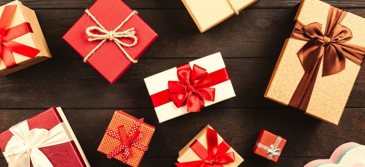 Wrapped gift boxes with red ribbons on a wooden table: FBT and tax rules for staff Christmas gifts and parties, Wiselink Accountants Melbourne and Brisbane