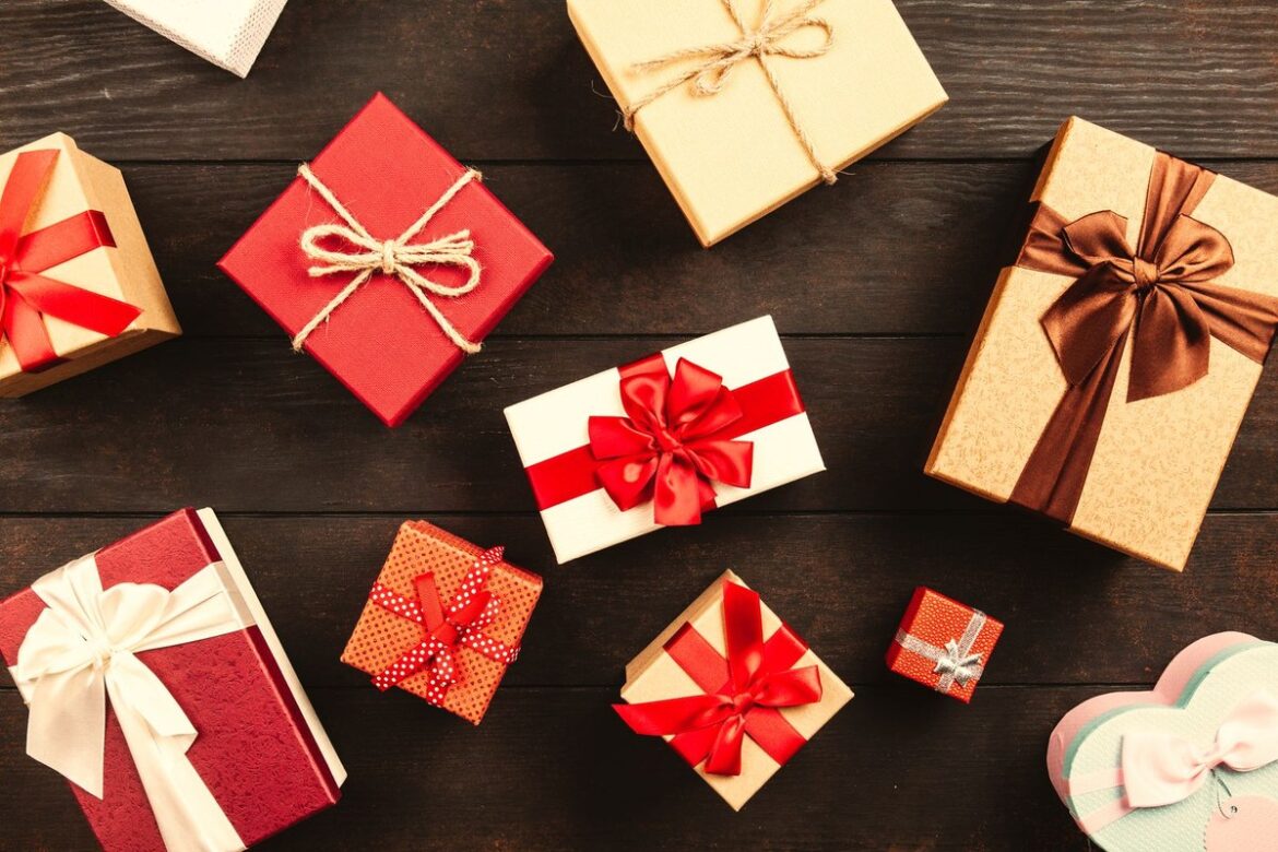Wrapped gift boxes with red ribbons on a wooden table: FBT and tax rules for staff Christmas gifts and parties, Wiselink Accountants Melbourne and Brisbane