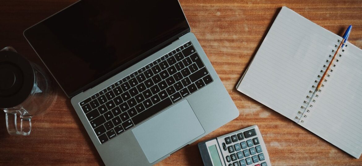 Laptop, calculator and notebook on a wooden desk: checking Payday Super contributions before 28 October 2026