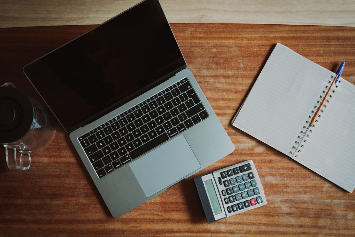 Laptop, calculator and notebook on a wooden desk: checking Payday Super contributions before 28 October 2026